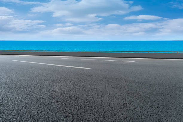 istock Empty highway asphalt road with beautiful sky ocean landscape 1015725602