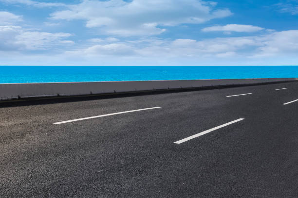 istock Empty highway asphalt road with beautiful sky ocean landscape 1015725614