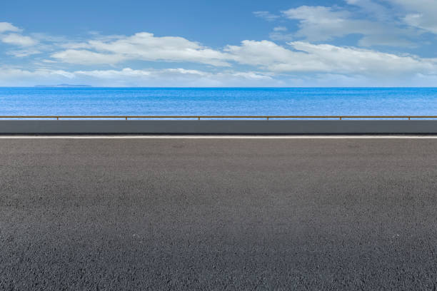 istock Empty highway asphalt road with beautiful sky ocean landscape 1015725928