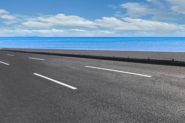 istock Empty highway asphalt road with beautiful sky ocean landscape 1015725938