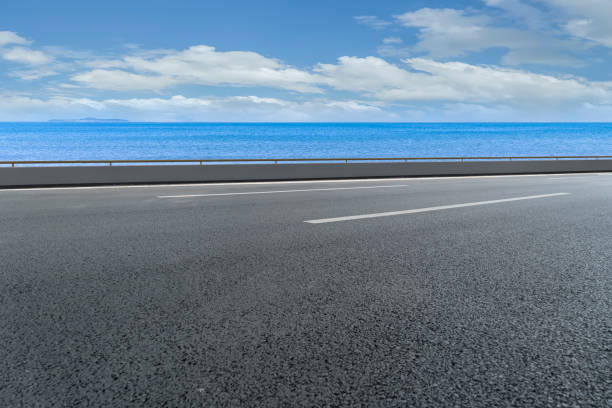 istock Empty highway asphalt road with beautiful sky ocean landscape 1015730132