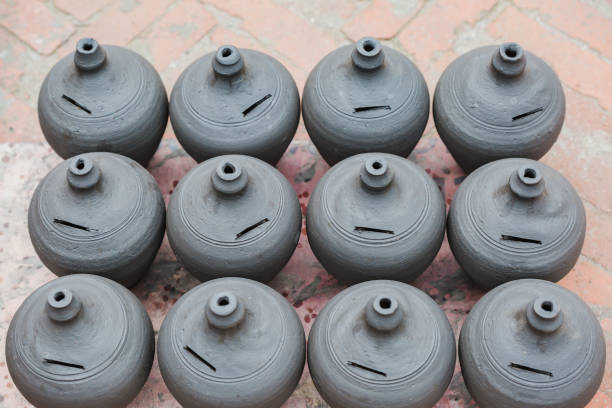 Indian woman arranges clay pots in The Pink City of Jaipur, Rajasthan, India. Jaipur is known as the Pink City, because of the color of the stone exclusively used for the construction of all the structures.