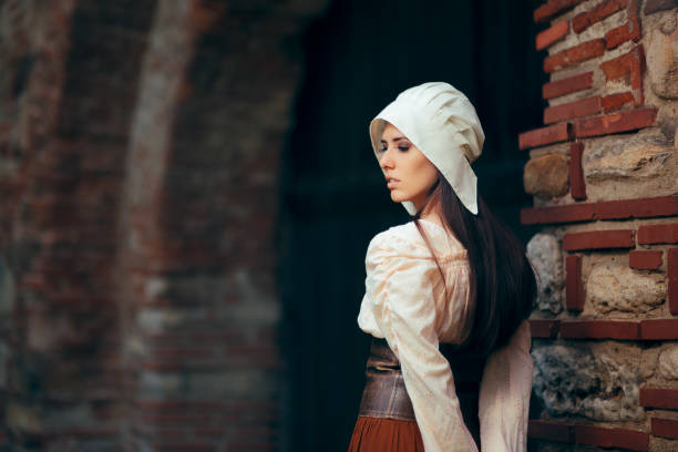 Medieval Woman in Historical Costume Wearing Corset Dress and Bonnet Medieval Woman in Historical Costume Wearing Corset Dress and Bonnet bonnet hat stock pictures, royalty-free photos & images