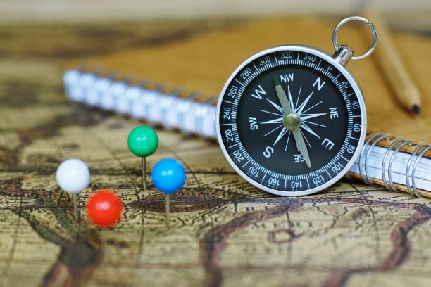 istock Compass, notebook and marking pins on blur vintage world map, journey concept, copy space 1015779210
