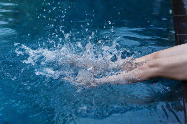 istock legs splashing in the pool 1015801884
