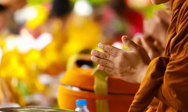 Photo of hand of monk in Buddhist prayer process.