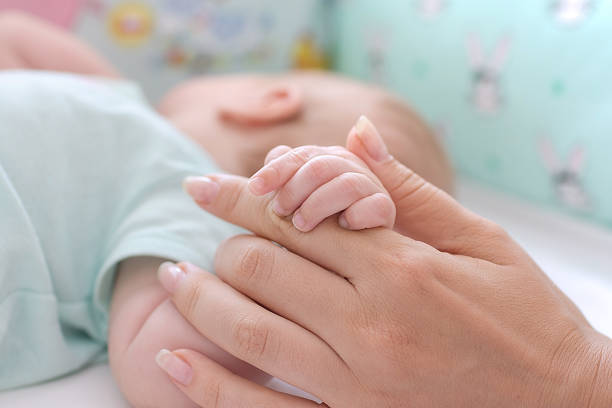 istock Baby hand in mother hand 1015839436