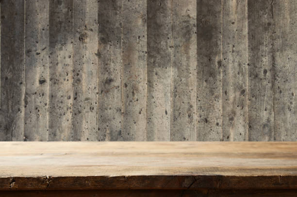 istock Empty table in front of exposed concrete textured wall background. For product display montage. 1015849874