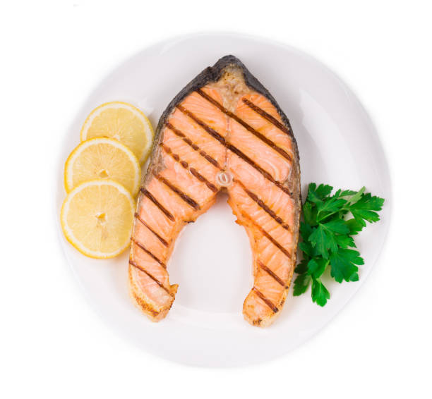 istock Fried salmon fillet on plate with lemon. 1015849882
