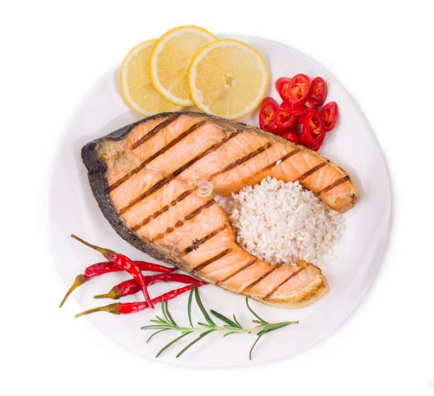 istock Fried salmon fillet on plate with lemon. 1015849916