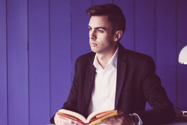 Pensive student reading book on business