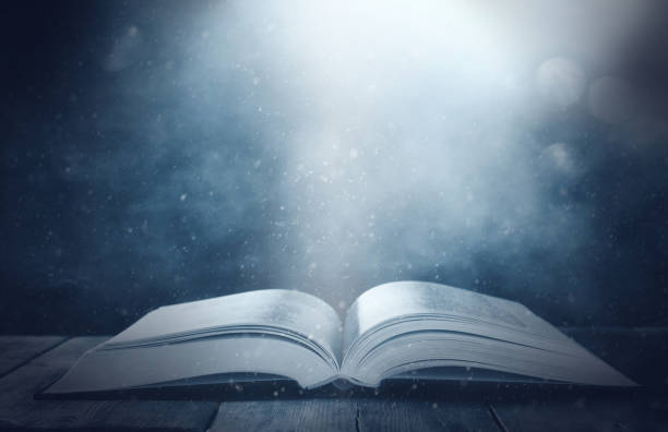 istock image of open antique book on wooden table. 1015858744