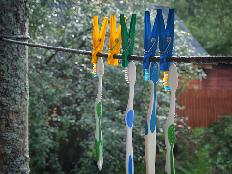 Filtered image of the toothbrushes hanging on a rope outdoor
