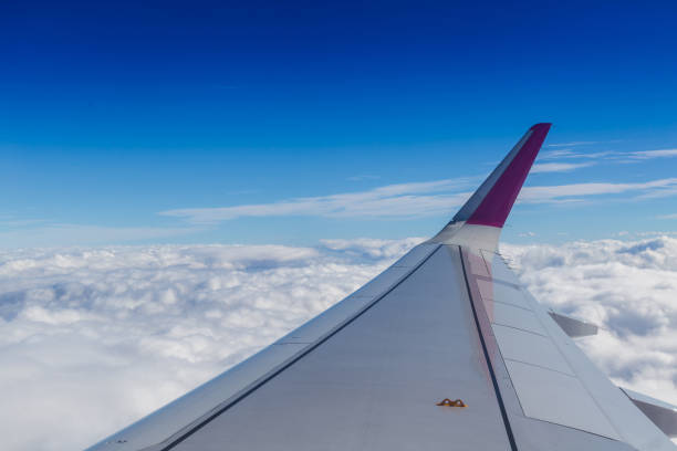 istock Blue horizon and white clouds. Aerial shot with airplane wing 1015859256