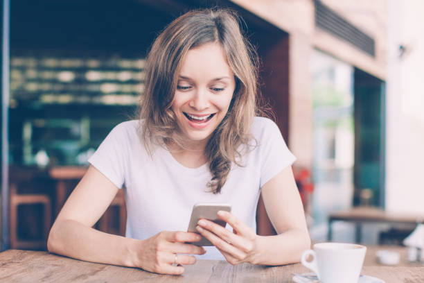 istock Excited Lady Using Smartphone in Outdoor Cafe 1015859386