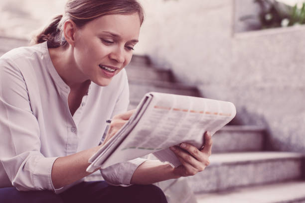 istock Content Lady Reading Newspaper on Stairs 1015859398