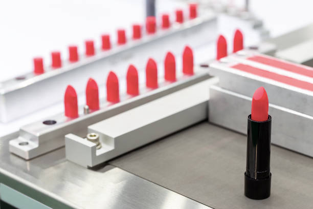 a lipstick vial filling machine in a cosmetics factory. - make up cosmetics beauty lipstick imagens e fotografias de stock