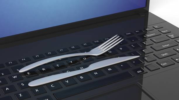 istock Fork and knife on laptop keyboard, conceptual background. 1015864002