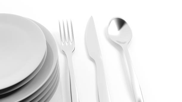 istock Silver fork, spoon and knife with a stack of plates, isolated on white background. 1015864056