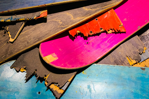 Broken colourful skateboard decks stacked on top of each other, skateboard recycling