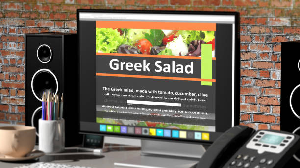 istock Monitor with Greek Salad recipe on desktop with office objects. 1015867746