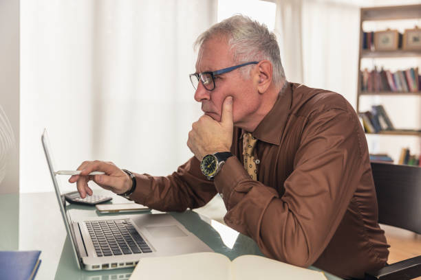 istock Mid aged mature man with tie and brown shirt working in office. 1015875964