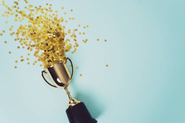 gold winner cup on blue  background image of little gold cup , concept for winning or success confetti photos stock pictures, royalty-free photos & images