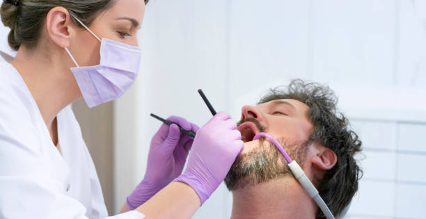 istock Man getting his teeth repaired by female dentist 1015890360