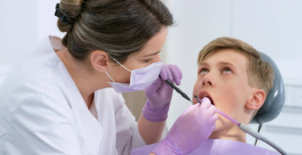 istock Boy getting his tooth repaired at dentist's office 1015890372