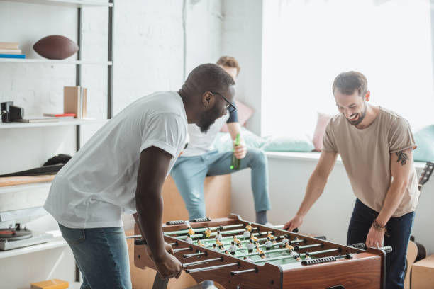 istock two young multiethnic friends playing table football 1015899670