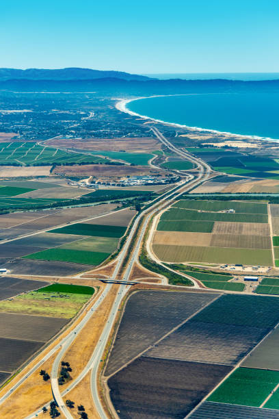 Farmland and Freeway 101 in California Pacific coast of California with farmland around freeway 101 and Monterey Bay visible in the up right corner. The picture was taken in the early July. city of monterey california stock pictures, royalty-free photos & images
