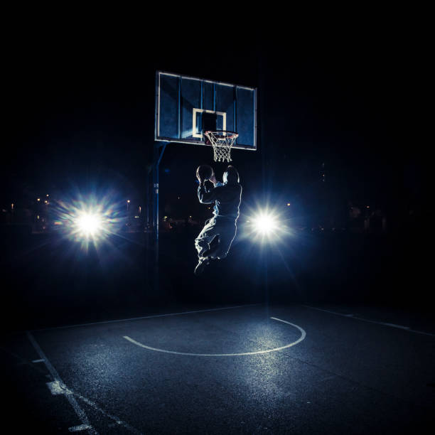 istock Young man playing basketball at night 1015903580