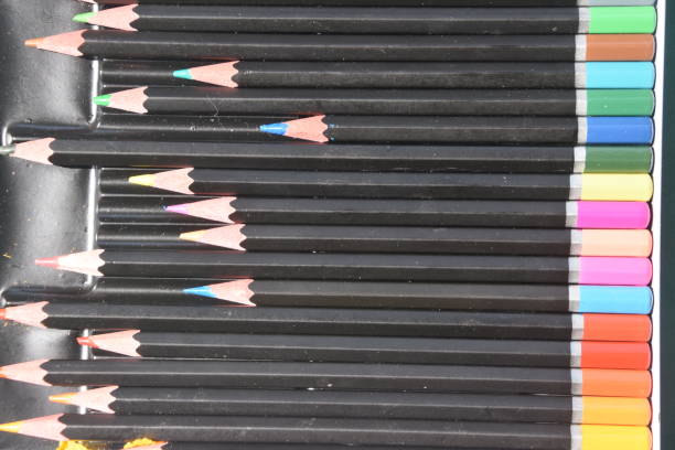Child holding many colorful wooden pencils with copy space.