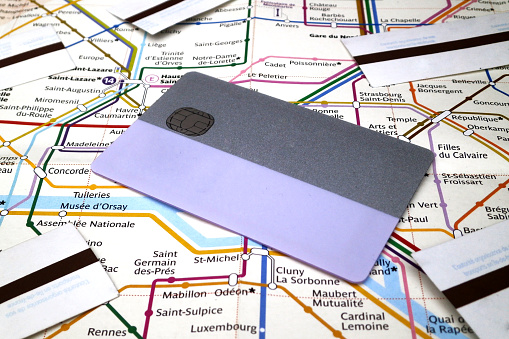 Paris, France - October 09 2017: A subway pass card and subway tickets on the top of a Paris Metro map. The card allows to travel in all Grand Paris during 2 weeks or one month while subway tickets are daily and doesn't cover all the zone unless if ones pay for it.