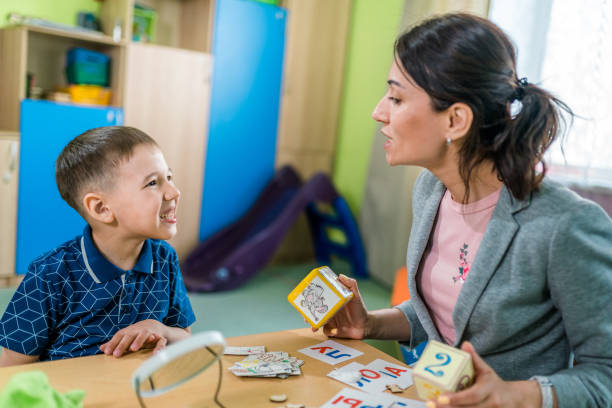 istock Woman Speech Therapist and Boy During Lesson to Correctly Articulation 1015922180