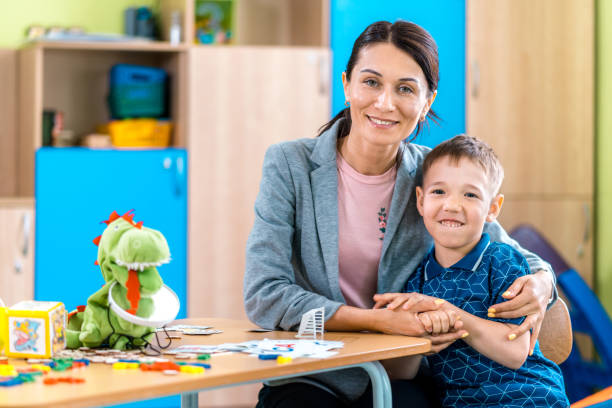 istock Friendly Woman Speech Therapist and Her Pupil Boy 1015922342