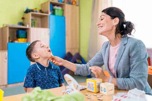 istock Friendly Woman Speech Therapist and Her Patient Boy at Speech Therapy Session 1015922426