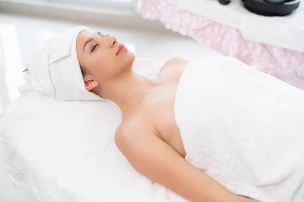istock Relaxed young woman lying on spa bed for massage. 1015927330