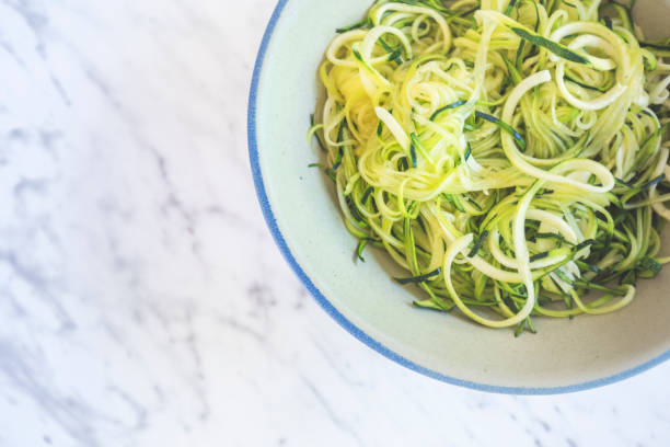 istock Zucchini spaghetti or noodles (zoodles) in a bowl with marble background Top view overhead 1015928356