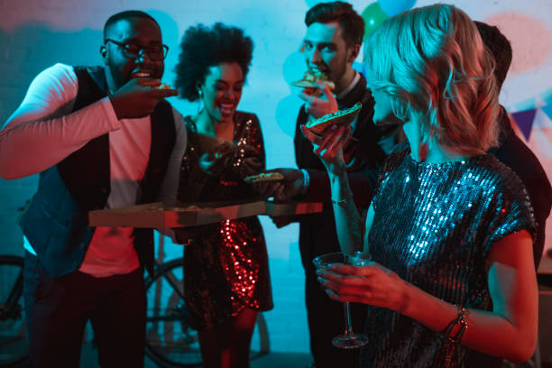 istock Partying diverse people eating pizza and holding drinks 1015928438