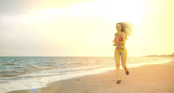 istock Attractive woman runs on sand beach in summer. 1015933282