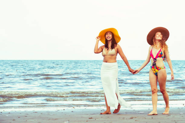 istock Happy women go sunbathing at sand beach in summer. 1015933658