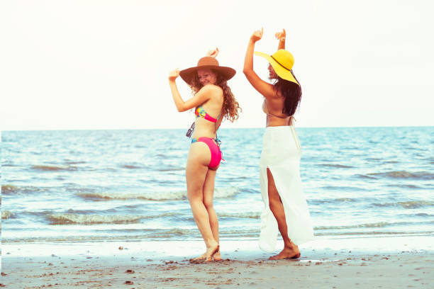 istock Happy women dance on sand beach in summer. 1015933786