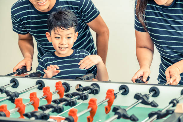 istock Happy kid playing foosball table with family. 1015933832