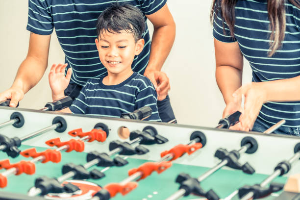 istock Happy kid playing foosball table with family. 1015933850
