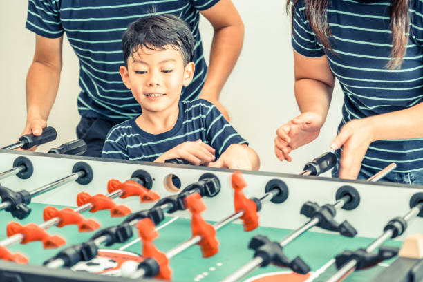 istock Happy kid playing foosball table with family. 1015933858