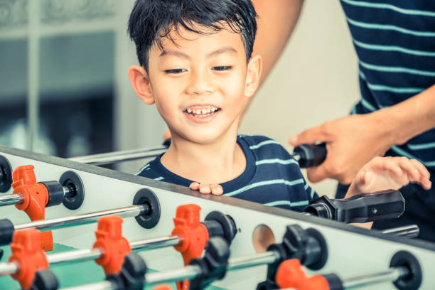 istock Happy kid playing foosball table with family. 1015933862