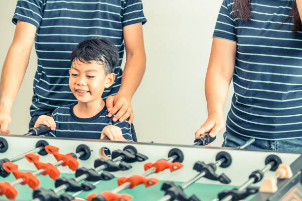 istock Happy kid playing foosball table with family. 1015933902