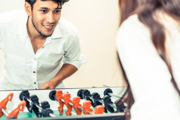 istock Happy couple playing foosball table. 1015933962