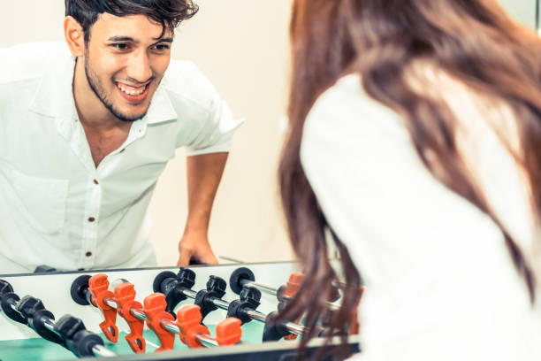 istock Happy couple playing foosball table. 1015933990